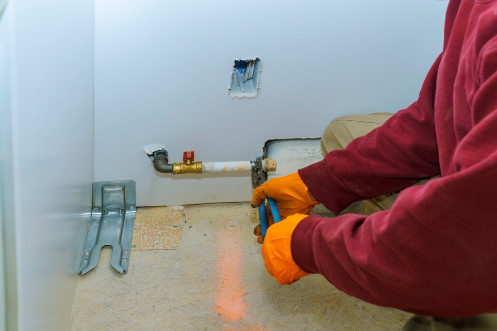 Man installing a gas appliance hob in a kitchen.