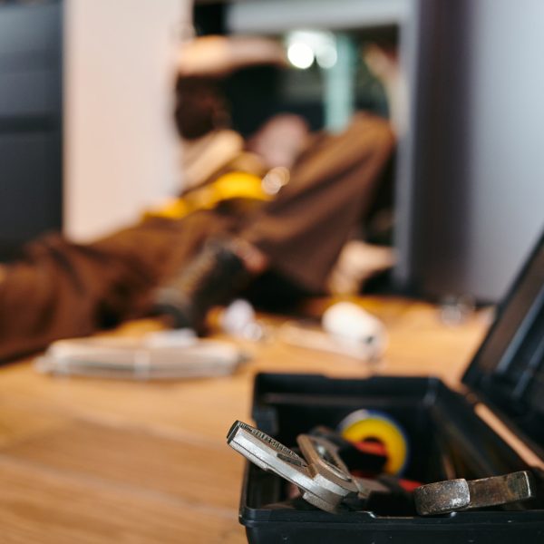 Toolbox with repairment handtools against plumber working